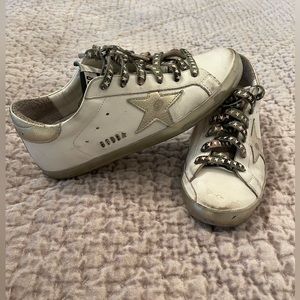 Golden goose white with gold star and camo laces.